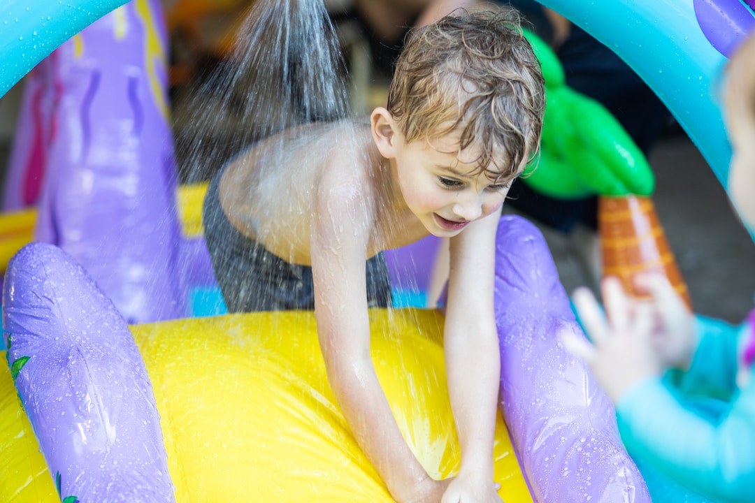 great-neck-2 A small boy having fun on an inflatable water slide.